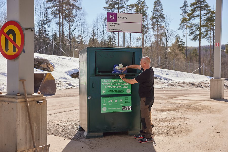 Person slänger avfall på återvinningscentral